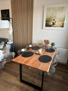 una mesa de madera con sillas alrededor en la sala de estar en U jelena Harrachov - apartmán u lesa s garáží, en Harrachov