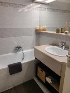 a bathroom with a sink and a bath tub at T2 climatisé à 5 minutes à pied de la plage avec parking, piscine et wifi in Fréjus
