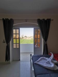 a bedroom with a bed and a door with a view at Dream Garden Luxor in Luxor