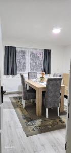 uma sala de jantar com uma mesa de madeira e cadeiras em Apartman Branka em Niška Banja