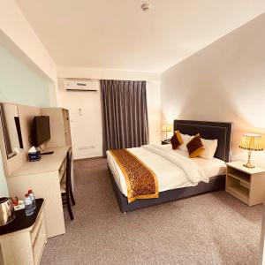 a hotel room with a bed and a television at Aquavista Hotel & Suites in Aqaba