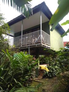 una casa con un balcón en el lateral. en Hospedaje Rio Celeste Katira, Habitación privada, en San Rafael