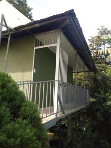 a small house with a porch and a balcony at Hospedaje Rio Celeste Katira, Habitación privada in San Rafael