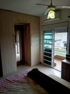 sypialnia z łóżkiem i przesuwnymi szklanymi drzwiami w obiekcie Casa Sobrado com piscina Santa Felicidade 6 pessoa w mieście Kurytyba