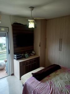um quarto com uma cama e uma televisão de ecrã plano em Casa Sobrado com piscina Santa Felicidade 6 pessoa em Curitiba