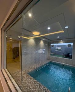 a swimming pool in a room with a glass wall at شاليهات الود in Abha
