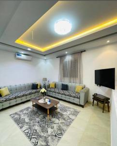een woonkamer met banken en een flatscreen-tv bij شاليهات الود in Abha