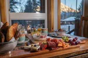 ein Tisch mit Brot und verschiedenen Arten von Speisen darauf in der Unterkunft Beaujolais Boutique B&B at Thea's House in Banff