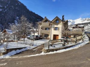 een huis met een hek aan de kant van een weg bij Chalet Migazzi - mansarda in Cogolo