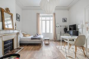 - un salon avec un lit et une table dans l'établissement Les Appartements à Gambetta, à Bordeaux