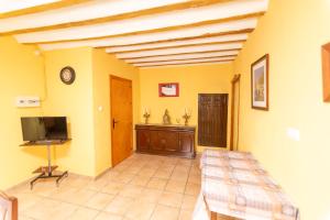 ein Wohnzimmer mit gelben Wänden und einem Flachbildfernseher in der Unterkunft Vivienda Puente de Tramaya in Cazorla