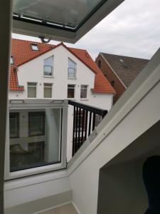 einen Balkon mit Blick auf ein Haus in der Unterkunft Dachzimmer mit Kochecke und Duschbad, nahe Messe in Hannover