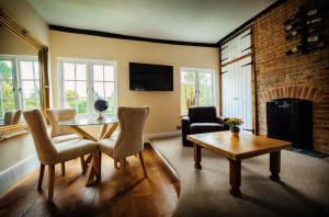 een woonkamer met een tafel en stoelen en een open haard bij Sheene Mill in Melbourn