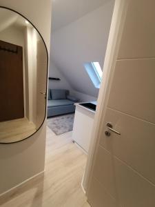 Zimmer mit einer Tür mit einem Spiegel und einem Sofa in der Unterkunft Dachzimmer mit Kochecke und Duschbad, nahe Messe in Hannover
