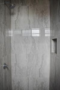 a shower with a glass door in a bathroom at Gran Hostal Tintorera in Puerto Villamil