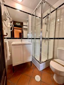 uma casa de banho com um chuveiro, um WC e um lavatório. em El Bulín de Patones em Patones