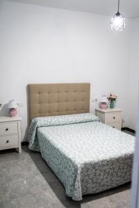 ein Schlafzimmer mit einem Bett und zwei Nachttischen in der Unterkunft Casa Hacha in Corteconcepción