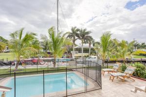 een balkon met een zwembad en palmbomen bij Waterfront Stuart Townhome with Private Pool! in Stuart