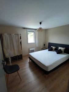 1 dormitorio con 1 cama blanca grande y 1 silla en Le Séchoir des acacias, Gite: Les Falaises, en Saint-Léon-sur-Vézère