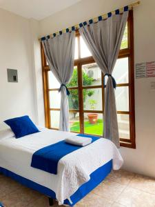 a bedroom with a bed and a window at Gran Hostal Tintorera in Puerto Villamil