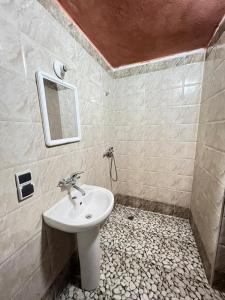 een badkamer met een wastafel en een spiegel bij Merzouga Lodge in Merzouga
