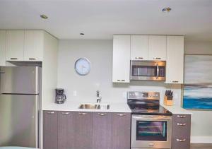 a kitchen with stainless steel appliances and a clock on the wall at Luxury Boutique 2 Bedroom Condo - 4B in Niagara Falls