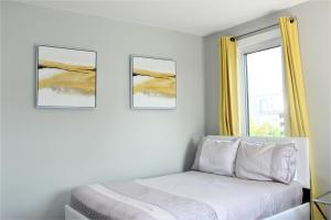 a bedroom with a bed and two pictures on the wall at Luxury Boutique 2 Bedroom Condo - 4B in Niagara Falls