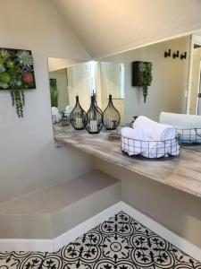 a room with a counter with vases and a mirror at The Nest Downtown Dunedin NO KIDS, NO PETS in Dunedin