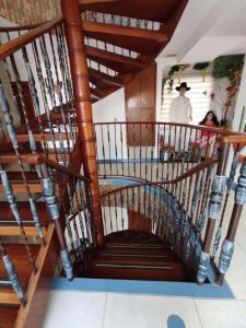 a wooden spiral staircase with a man standing in the background at Apartamento Villa llano in Villavicencio