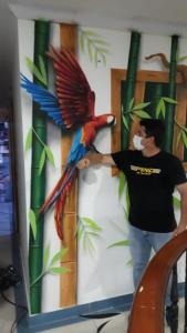 a man standing next to a parrot on a wall at Apartamento Villa llano in Villavicencio