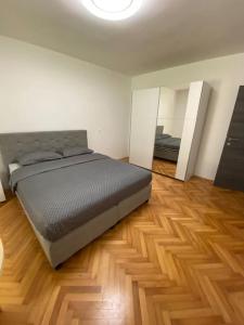 1 dormitorio con 1 cama grande y suelo de madera en Apartma na vinski kmetiji en Koper