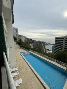een zwembad aan de zijkant van een gebouw bij Reñaca departamento in Viña del Mar
