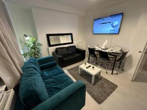 a living room with a blue couch and a table at 3 Bedroom King Cross station City centre London in London