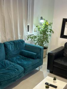 a living room with a blue couch and a table at 3 Bedroom King Cross station City centre London in London