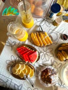 einen Tisch mit Teller mit Lebensmitteln und Obst in der Unterkunft Pousada Tupaiú in Alter do Chao