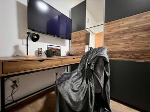 a room with a desk with a television and a bag at PrimeTime Suite für 2 mit Küche in Essen