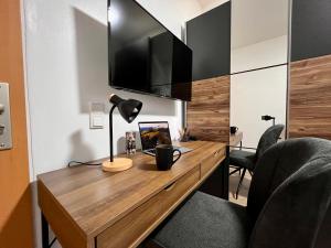 drewnianym biurkiem z lampką i krzesłem w obiekcie PrimeTime Suite für 2 mit Küche w Essen