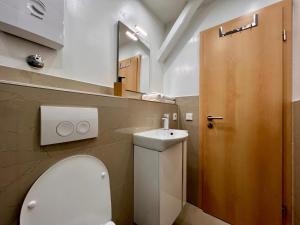 a bathroom with a white toilet and a mirror at PrimeTime Suite für 2 mit Küche in Essen