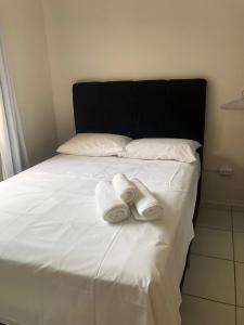 dos toallas están sentadas en una cama blanca en Comodidade e simplicidades a 240m do mar, en Florianópolis