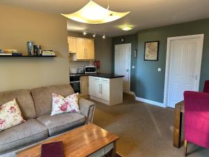 a living room with a couch and a kitchen at Beechcroft Corner House in Ecclesall