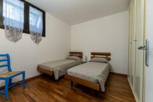 um quarto com 2 camas e uma cadeira azul em DA ERIK E NICHI em Negrar