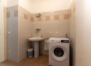 uma casa de banho com uma máquina de lavar roupa e um lavatório em DA ERIK E NICHI em Negrar
