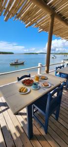 a picnic table with food on it on a deck at Restaurante & Pousada Gaivota in Santo André