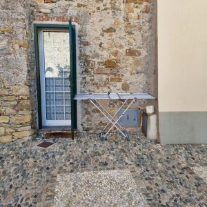a table against a brick wall next to a window at Casa Vacanze AL TEATRO in Diano Castello