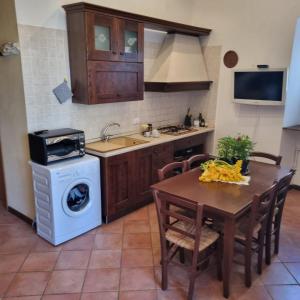 a kitchen with a table and a washing machine at Casa Vacanze AL TEATRO in Diano Castello