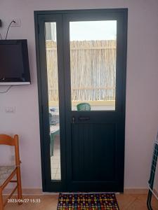 Una puerta negra en una habitación con TV en Appartamenti Regina Margherita, en Calasetta