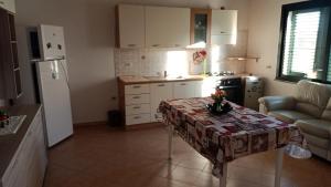 una pequeña cocina con mesa y nevera en Appartamenti Regina Margherita, en Calasetta