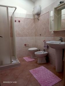 y baño con lavabo, aseo y ducha. en Appartamenti Regina Margherita, en Calasetta