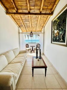 ein Wohnzimmer mit einem Sofa und einem Tisch in der Unterkunft Hotel Puerto Antiguo in Los Órganos