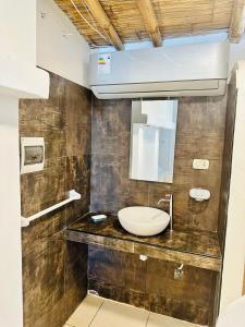 ein Bad mit einem Waschbecken und einem Spiegel in der Unterkunft Hotel Puerto Antiguo in Los Órganos